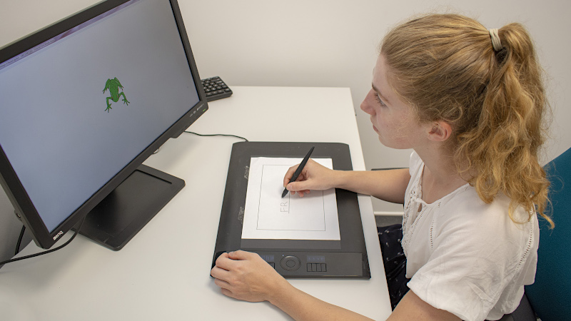 Person carrying out a handwriting test on a digitising tablet